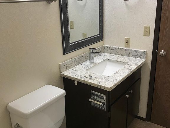 Bath with Granite Counter Tops and Framed Mirror
