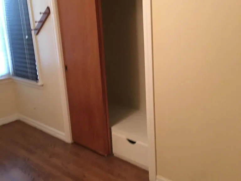Bedroom closet with overhead storage cabinets