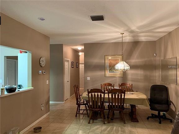 Dinning Area of Great Room with tile floor showing pass-thru to kitchen foyer and hall to Bedrooms & Laundry
