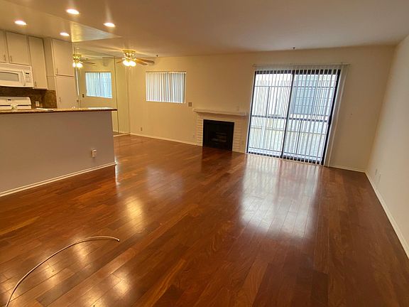 Living room with sliding glass door to emergency walkway- NOT a balcony. Gas fireplace. Dining area