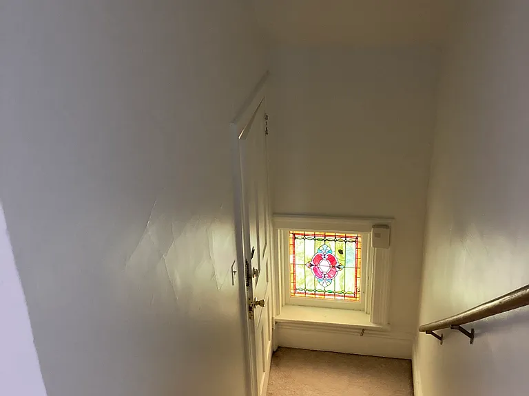 Spectacular stained glass window in entry stairway to apartment.