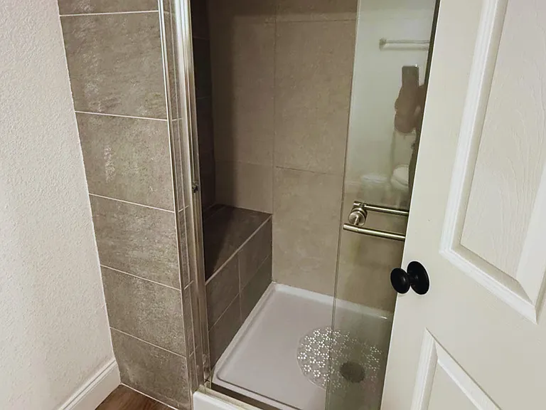 Immaculate modern shower with bath mats for added comfort.