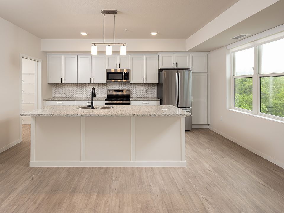 Kitchen with oversized island and beautiful tile backsplash in Neil Armstrong 302