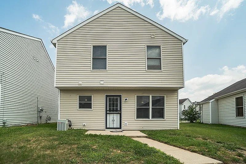 Two-story home with durable siding, large rear windows providing natural light, and a private backyard space.