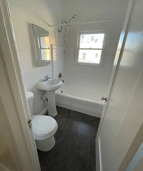 Bathroom with white fixtures and natural light in apartment unit of Molino Del Mar Apartments in Pasadena, California.