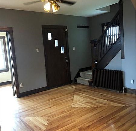 View from dining room towards front door. The pristine hardwood floors with custom border and intricate design showcases the cra