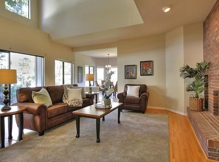 Family Room with High Ceilings, Fireplace and Walls of Windows Filling the Home with Natural Light