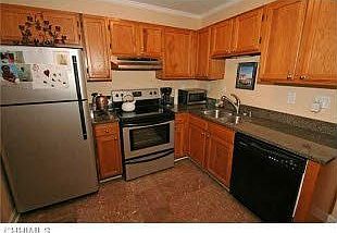 Stainless steel appliances, with black dishwasher, and trash compactor..