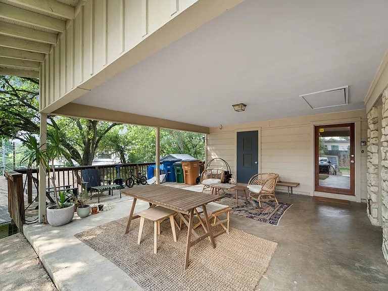 Carport. Car charger on pole left side. Two storage closets on right side. A/C closet behind dark color door.