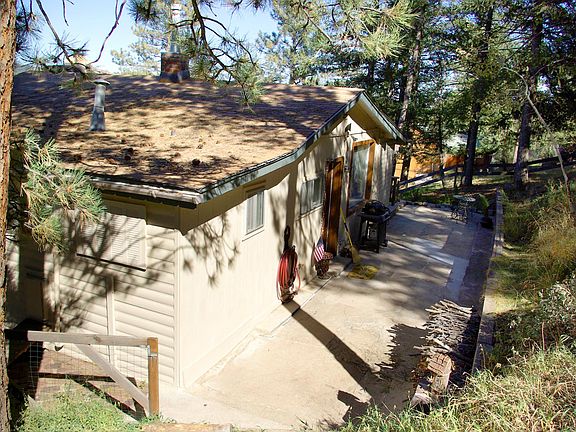 Patio at back of house on forested mountainside.