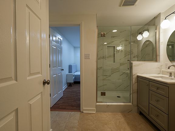 Beautiful, tiled, large ensuite bathroom with storage closet.