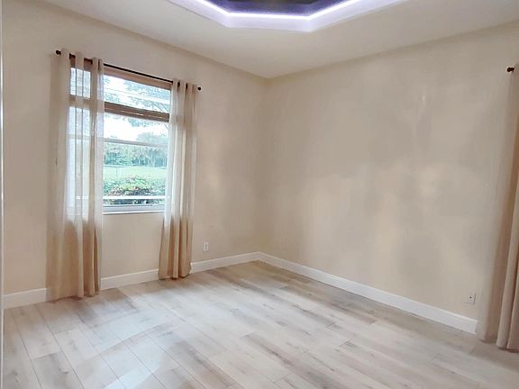 Master bedroom with a unique ceiling design and multicolor LED lighting.