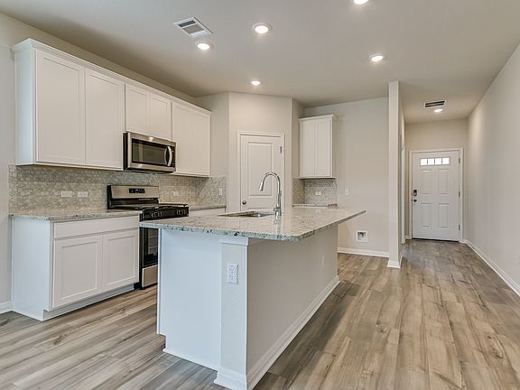 This beautiful kitchen includes linen-colored cabinets and granite countertops.
