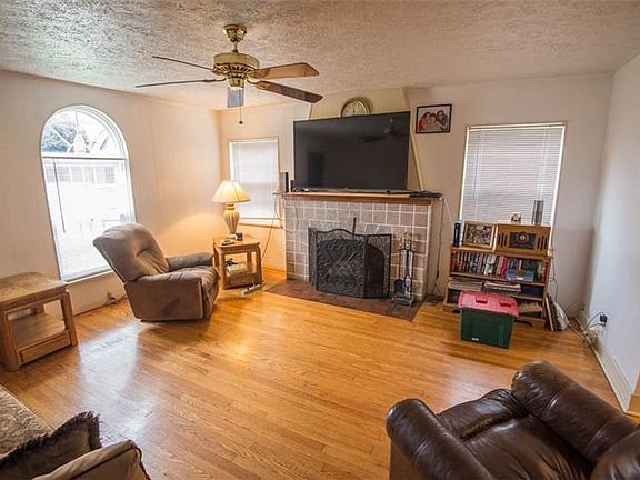 Living room of 1101 Oregon with fireplace, hardwood floors and lots of windows to allow for a lot of natural light to flow in.
