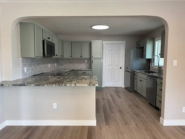 Kitchen with all new appliances, cabinets, and granite countertops. Kitchen appliances include: Induction Stove, Refrigerator/Freezer, Microwave, Dishwasher.