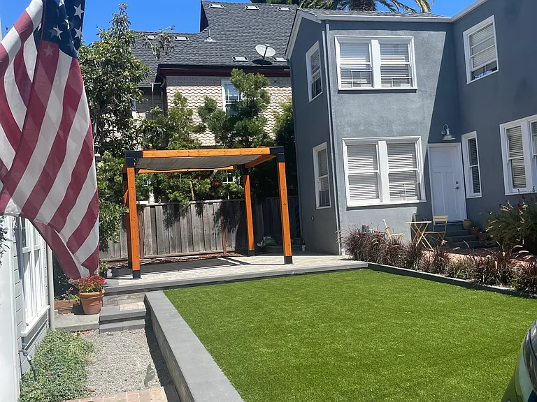 New landscaping in the courtyard separating the front building and the carriage house. Turf, pavers and shaded pergola area.