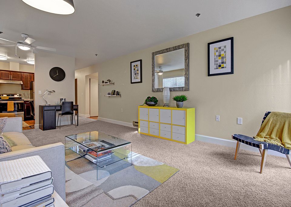 Living room with couch, desk, and view into the kitchen