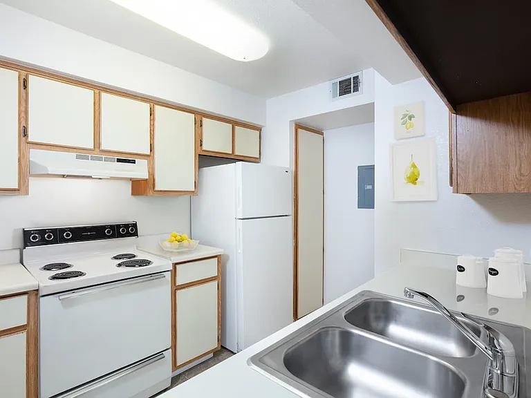 Classic Package I kitchen with white appliances, beige and brown cabinetry, and laminate countertops