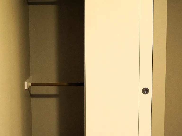 Secondary bedroom closet with double hanging rods.