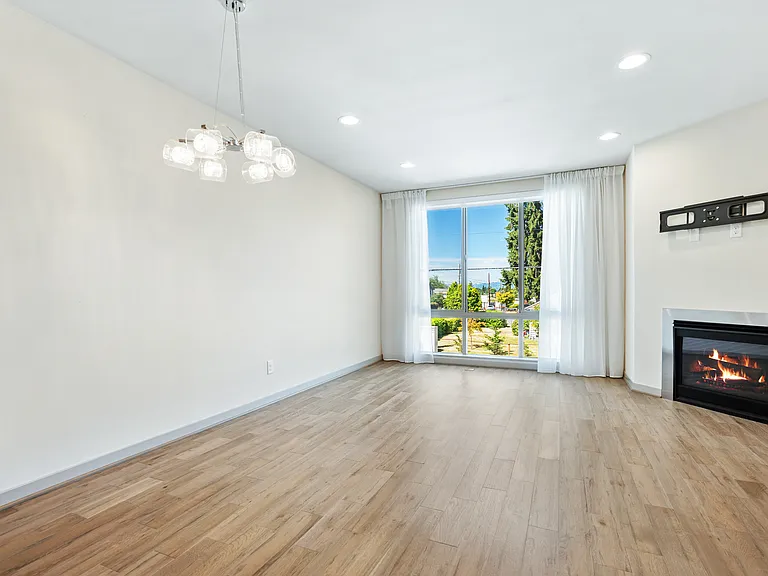 Dining room and living room, with floor to ceiling windows and cozy gas fireplace.
