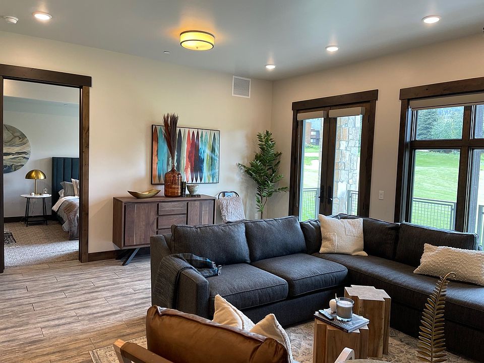 Living room with view of golf course. Furniture will be replaced with new furniture, including sofa, chairs, coffee table, and dining table for six people.