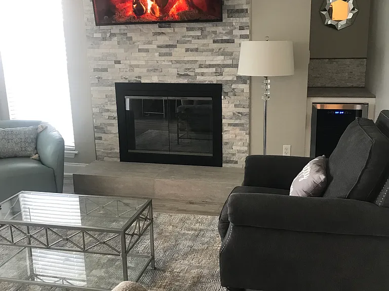 Living room with a view of the lake and wine cooler nearby.