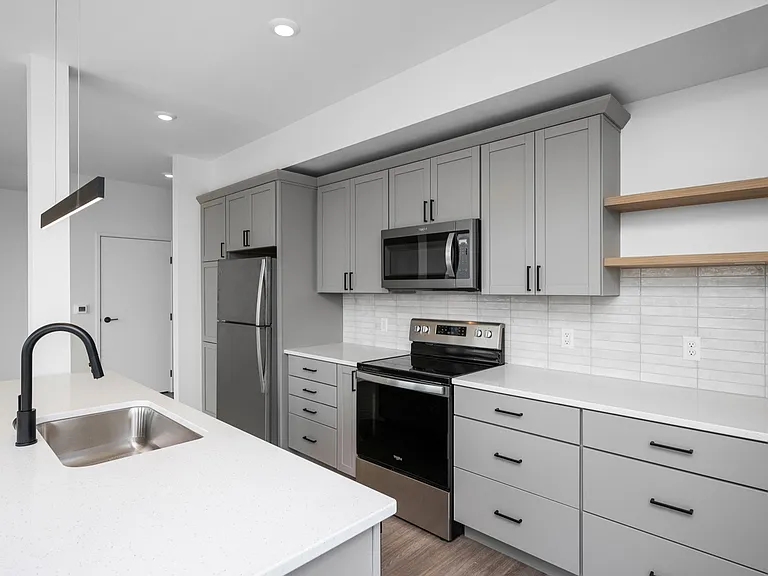 Modern kitchen with sleek gray cabinetry, stainless steel appliances, and elegant white countertops, embodying a chic and functional design. Modern kitchen with sleek gray cabinetry, stainless steel appliances, and elegant white countertops, embodying a c