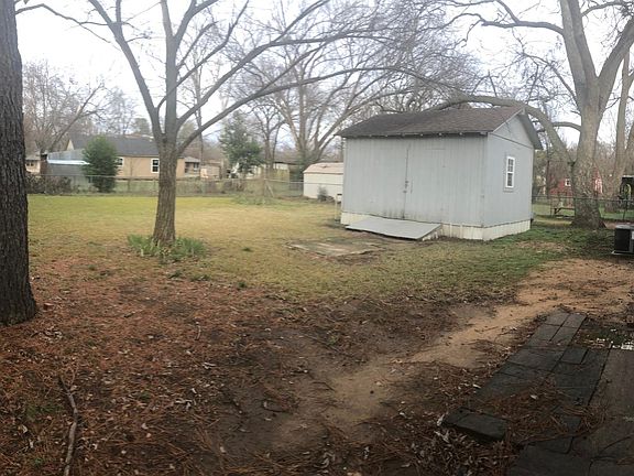 View of the large fenced backyard and shed from the 2nd gate.