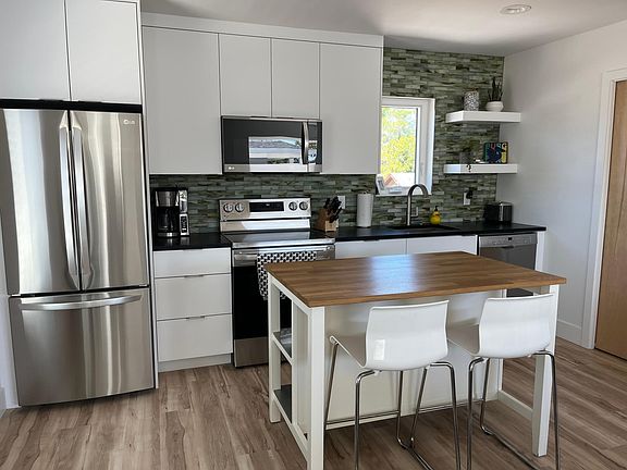 A great kitchen island with bar seating and shelf storage on other side and a full-sized LG refrigerator.