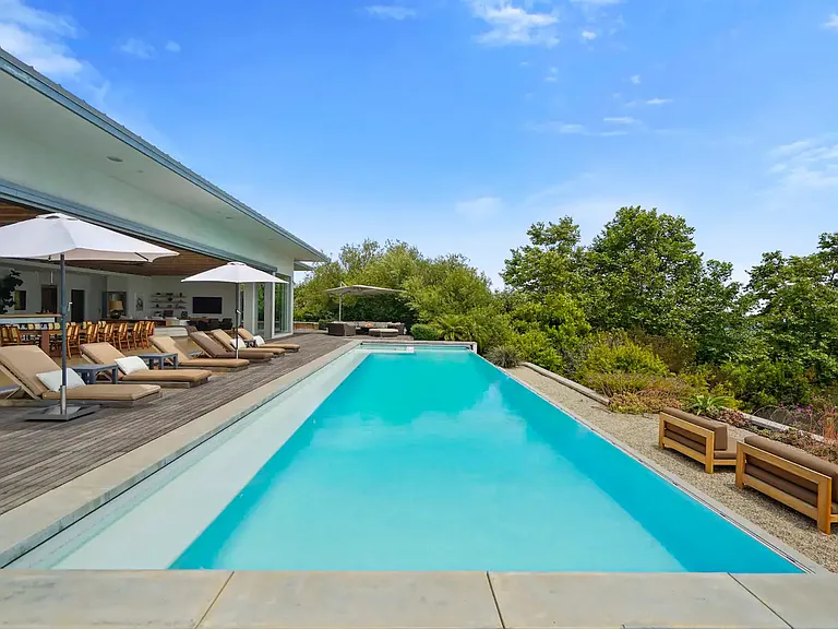 Discover an expansive pool area boasting a sophisticated deck and luxurious amenities.