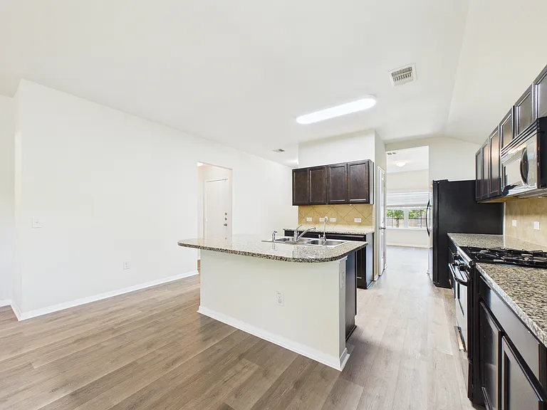 Kitchen has espresso cabinets and granite counter tops