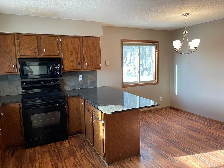 Granite countertops, wood floor, and newer appliances