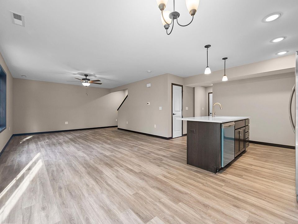 Open concept kitchen, dining area and living room. Ceiling fan in living room, sliding doors off dining area leading to patio.