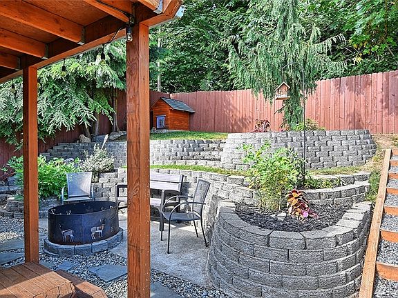 Warm up by the fire and relax after a long day at work in this beautifully landscaped backyard!