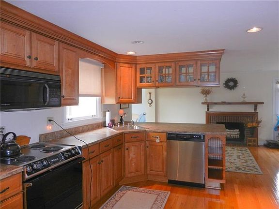 LOTS OF CUPBOARDS AND COUNTER SPACE IN THE KITCHEN WITH EATING SPACE AND FIREPLACE
