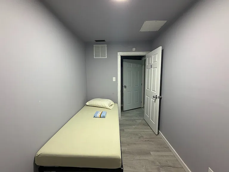Efficient private bedroom with a twin bed, neutral walls, and durable plank-style flooring for easy upkeep.