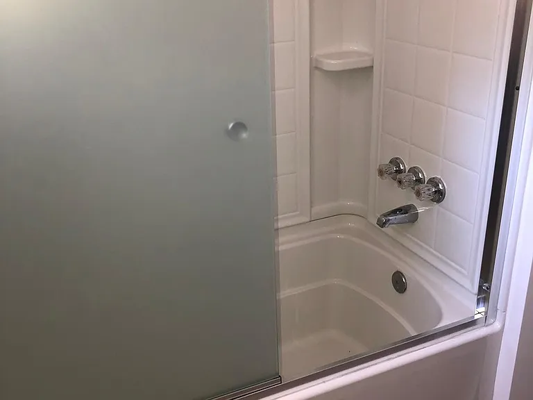 Enclosed bathtub with sliding glass door