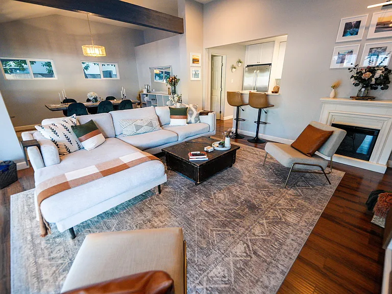 Natural light from the large outdoor patio streams into the living room with ample seating