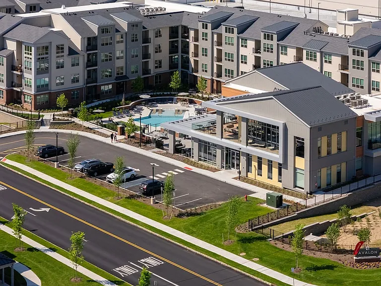 Aerial view of the expansive two-level clubhouse, resort-style pool, and apartment exteriors