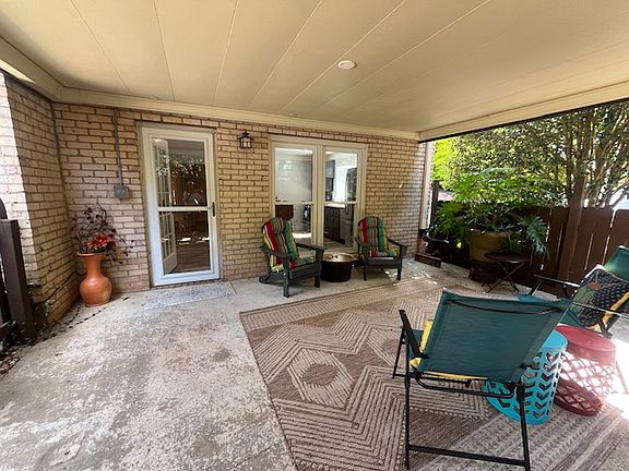Entrance from apartment to furnished covered porch off of inground pool