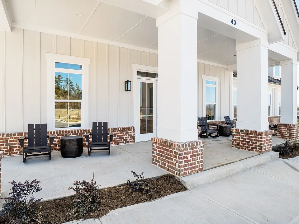 Clubhouse exterior porch with rocking chairs to relax and unwind.