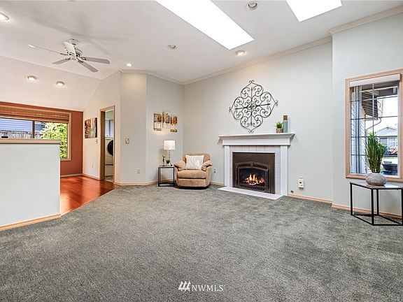 Front sitting room includes skylights, gas fireplace and ceiling fan.