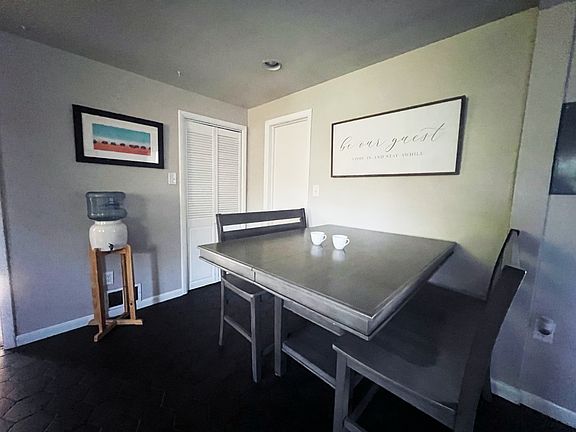 Kitchen area that leads to back courtyard area with screen door, washer/dryer area and bathroom 2.
