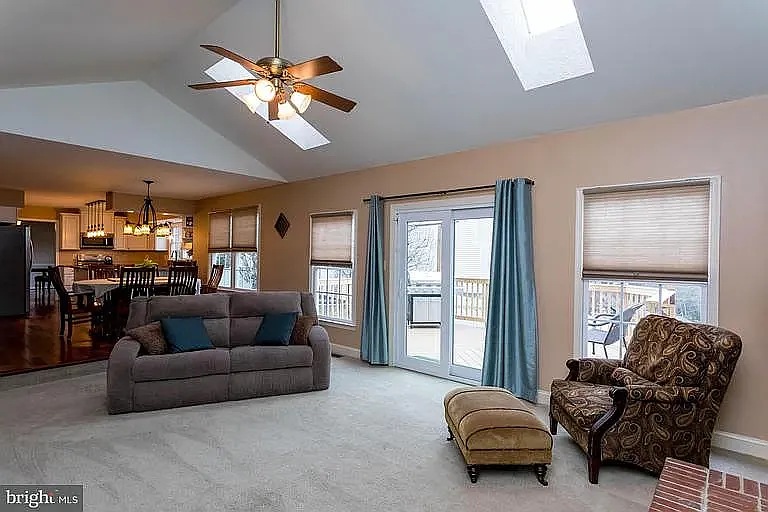 Main Floor Family Room with view onto the deck and into the kitchen. Patio door has been replaced, there is also an automatic electronic doggie door allowing your pet into the fenced yard or back into the house (very convenient).