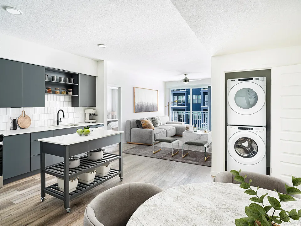 A bright, open layout featuring a dark-cabinet kitchen, movable island, and in-home washer and dryer, creating everyday ease at Modera Encore in Tampa.