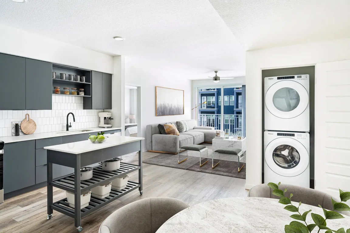 A bright, open layout featuring a dark-cabinet kitchen, movable island, and in-home washer and dryer, creating everyday ease at Modera Encore in Tampa.