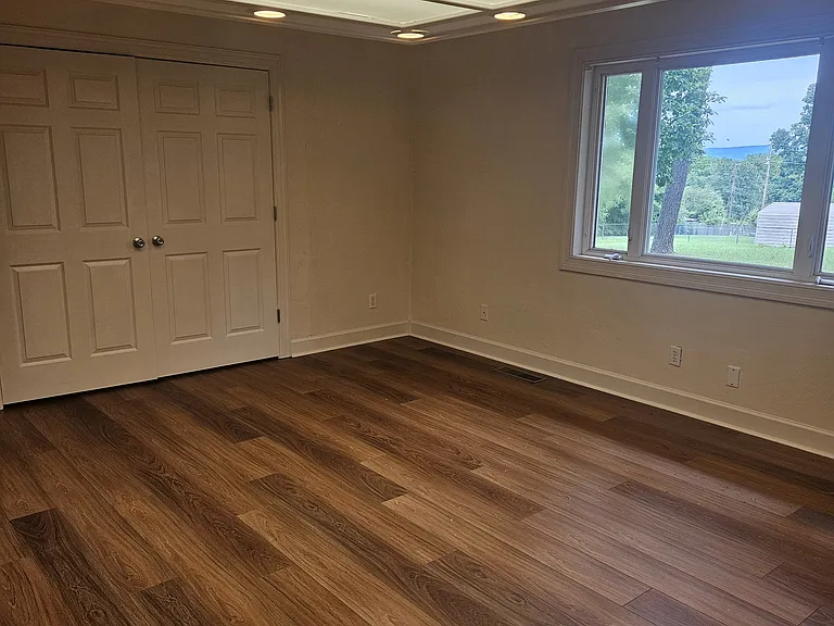 Bedroom 1 with new floor and view of the huge backyard.