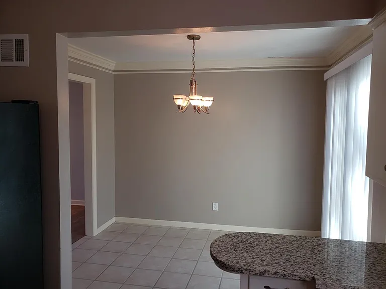 Dining area open to the kitchen with new granite countertops. Sliding doors behind vertical blinds leads to back deck.