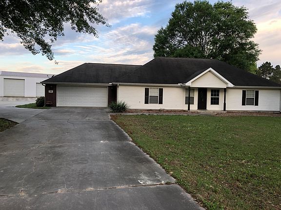 Front of home with wrap-around driveway.