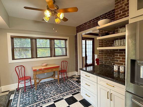 The brand new kitchen has exposed brick walls, brand new professional appliances, thick granite countertops and access to both the side and rear patios.